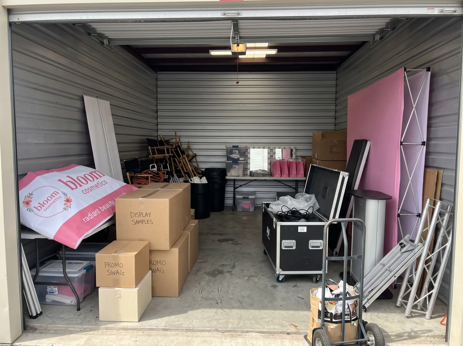 Illustrative storage unit filled with beauty event displays, boxes, and booth equipment