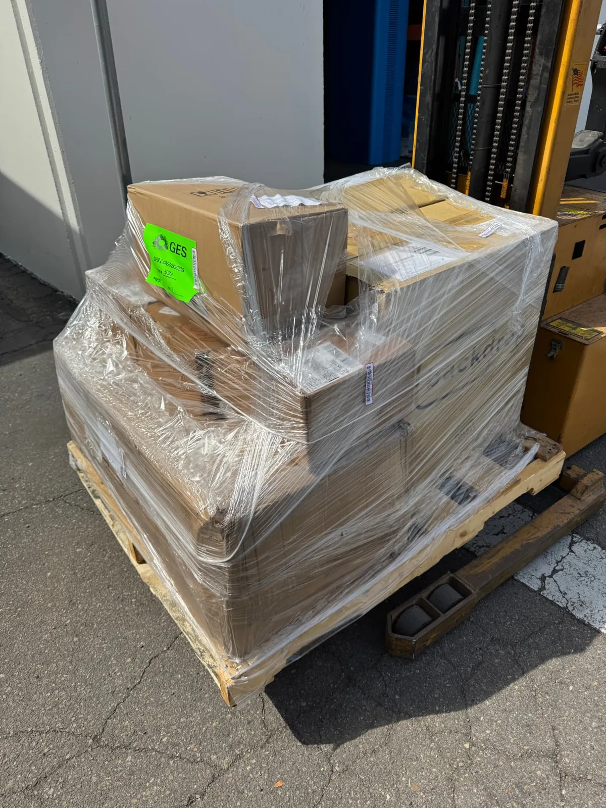 Palletized booth freight secured with stretch wrap on a forklift, ready for transport